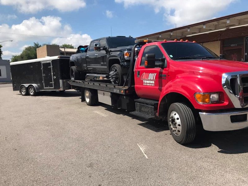 All Out Towing Nashville Tennessee Black Truck and Trailer towed by Flatbed Tow Truck