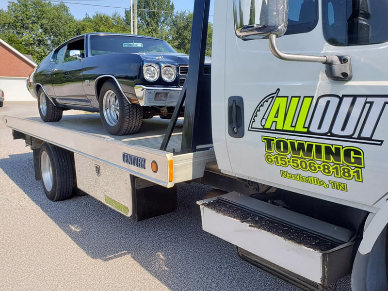 All Out Towing Nashville Tennessee Blue Sports car towed by Flatbed Tow Truck