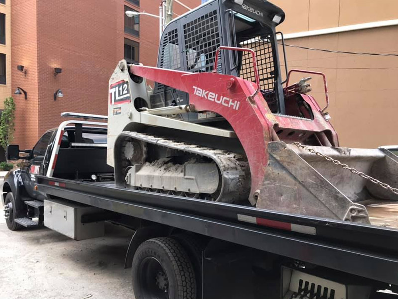 All Out Towing Nashville Skid Steer Equipment towed on flatbed tow truck